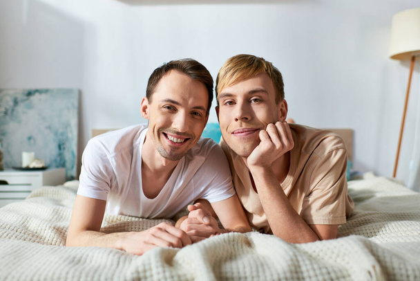 Двое мужчин в повседневной одежде лежали на кровати, разделяя момент близости и связи. - Фото, изображение