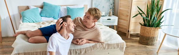 Zwei Männer liegen auf einem Bett und teilen einen Moment der Intimität. - Foto, Bild
