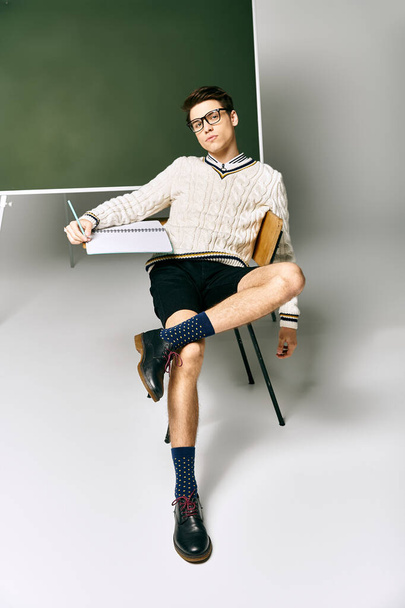 Ein Mann in Uniform sitzt vor einem grünen Brett in einem College-Klassenzimmer. - Foto, Bild