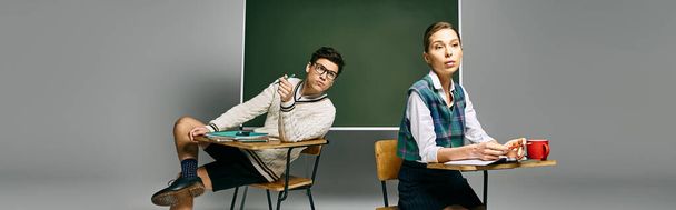 İki zarif öğrenci bir üniversite sınıfında bir masada oturmuş yeşil bir tahtayla uğraşıyorlar.. - Fotoğraf, Görsel