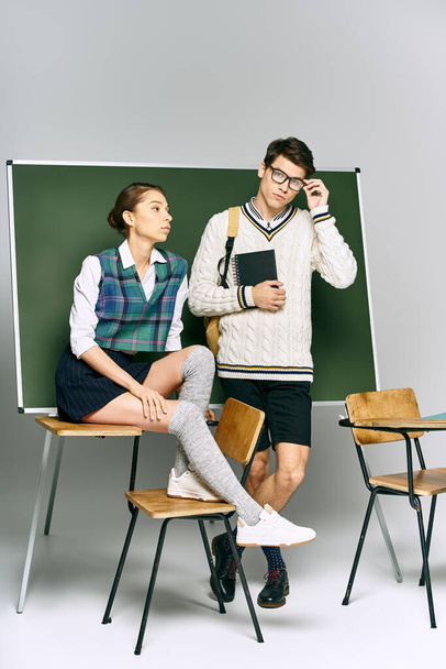 Elegantní muž a žena stojící vedle zelené desky na vysoké škole. - Fotografie, Obrázek