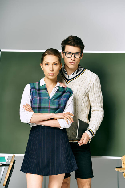 Елегантний чоловік і жінка студенти стоять перед зеленою дошкою в коледжі. - Фото, зображення