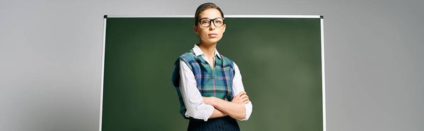 Hermosa estudiante de uniforme delante de un tablero verde. - Foto, Imagen