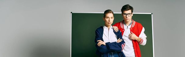 Два студента стоят вместе в классе колледжа, демонстрируя товарищество и академическую поддержку.. - Фото, изображение
