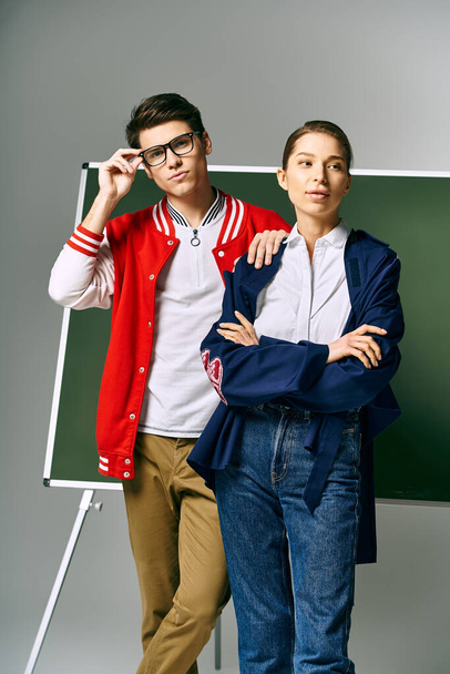 Bir erkek ve kadın öğrenci üniversite sınıfında yeşil bir panonun önünde duruyor.. - Fotoğraf, Görsel