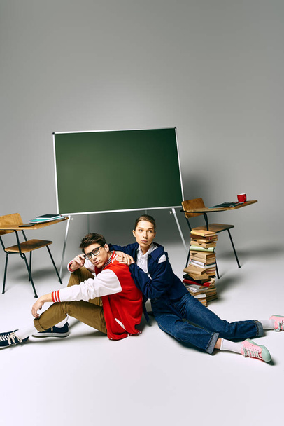 Ein Student und eine Studentin posieren vor einem grünen Brett in einem College-Klassenzimmer. - Foto, Bild