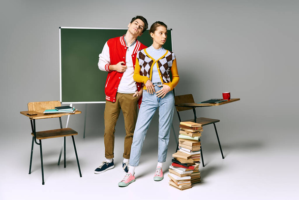 Stylowy mężczyzna i kobieta studenci pozować przed zieloną tablicą w klasie college 'u. - Zdjęcie, obraz