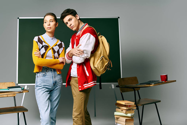 Dos estudiantes con estilo están de pie con confianza ante el tablero verde en un aula de la universidad. - Foto, imagen