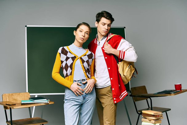 Jóvenes estudiantes masculinos y femeninos posan frente al tablero verde en un aula universitaria. - Foto, imagen