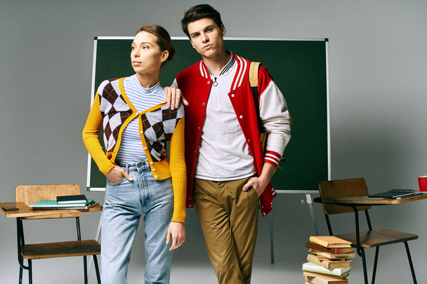 Un étudiant et une étudiante en tenue décontractée posant devant un tableau vert dans une salle de classe du collège. - Photo, image