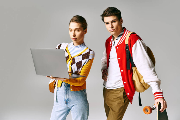 Casual college duo with laptop and skateboard. - Photo, Image