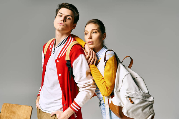 Nuori mies ja nainen opiskelijat, tyylikkäästi pukeutunut, poseeraa yhdessä college luokkahuoneessa. - Valokuva, kuva