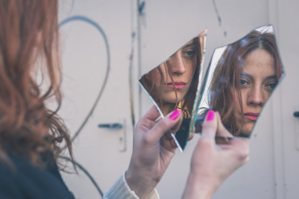 Beautiful girl looking at herself in a mirror - Photo, Image