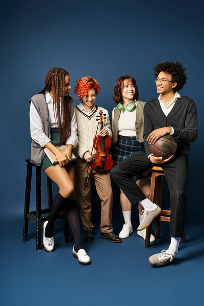 Eine Gruppe junger multikultureller Freunde posiert in stylischer Kleidung vor dunkelblauem Hintergrund für ein Foto. - Foto, Bild