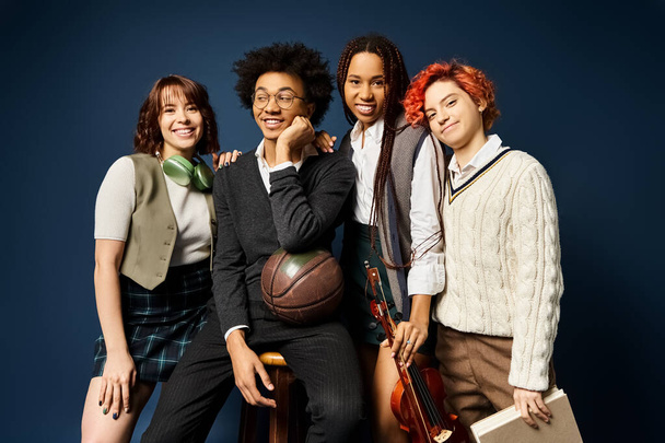 A group of young multicultural friends, including a nonbinary person, standing together in stylish attire on a dark blue background. - Photo, Image