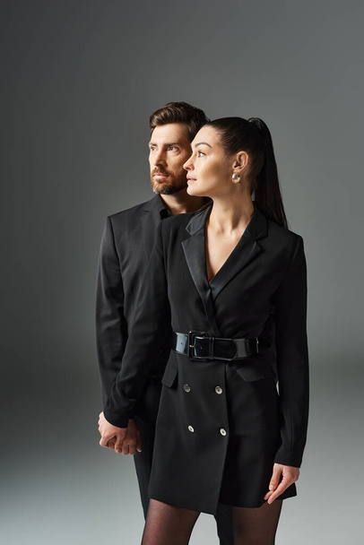 Un homme et une femme en tenue élégante debout ensemble dans une étreinte aimante. - Photo, image