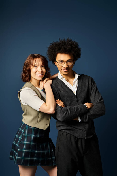 Ein Mann und eine Frau posieren in stilvoller Kleidung vor dunkelblauem Hintergrund. - Foto, Bild