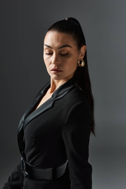 Eine Frau in einem schwarzen Kleid mit geschlossenen Augen. - Foto, Bild