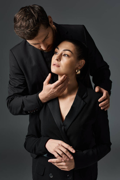 Ein Mann und eine Frau in eleganter Kleidung umarmen sich liebevoll. - Foto, Bild