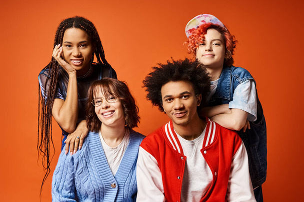 A young, diverse group in trendy outfits pose for a portrait in a studio setting, including a nonbinary individual. - Photo, Image
