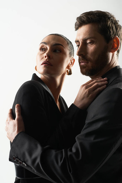 Man en vrouw in elegante kledij, opgesloten in een tedere omhelzing. - Foto, afbeelding