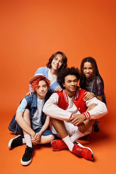 Eine Gruppe junger multikultureller Freunde, darunter eine nicht binäre Person, steht in stilvoller Kleidung zusammen und posiert für ein Foto. - Foto, Bild