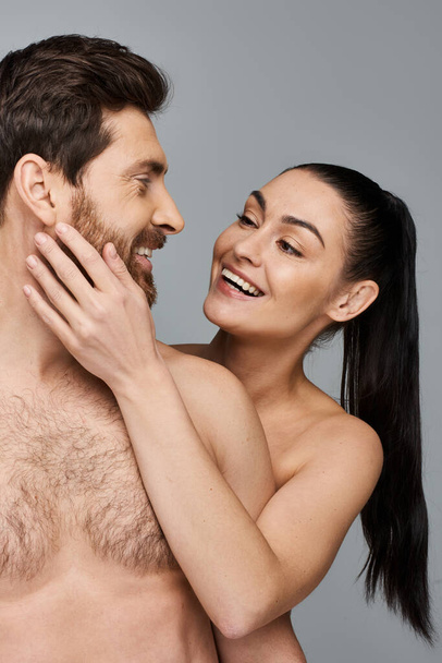 Ein Mann und eine Frau lächeln zusammen in freudiger Pose und strahlen Glück aus. - Foto, Bild
