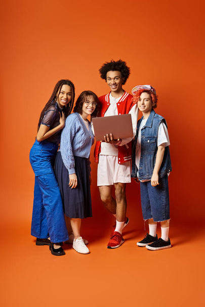 Young multicultural friends, including a nonbinary person, stand together in stylish attire in a studio setting. - Photo, Image