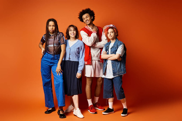 A group of young multicultural friends, including a nonbinary person, stand closely together in stylish attire in a studio setting. - Photo, Image