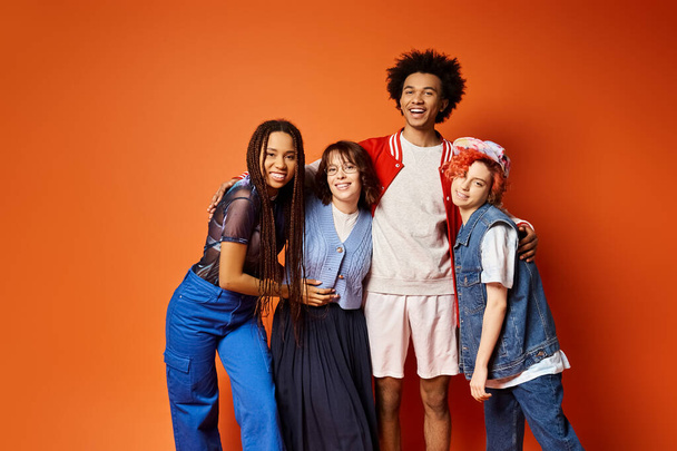 A diverse group of young friends, including a nonbinary person, stand together in stylish attire in a studio setting. - Photo, Image