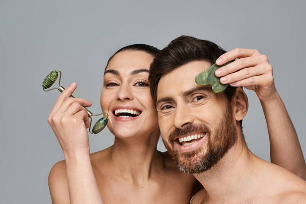 Jolly couple, radiating beauty, using face roller and gua sha together. - Photo, Image