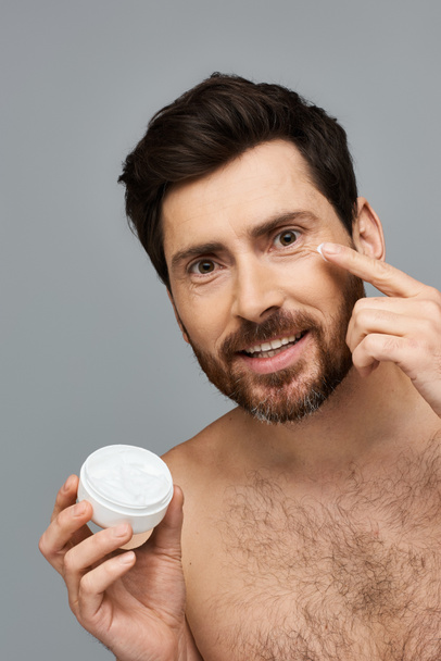 A fit man holds a jar of cream. - Photo, Image