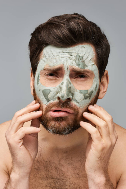 Un hombre con una máscara facial para el tratamiento del cuidado de la piel. - Foto, imagen