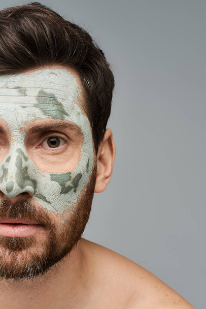 Hombre guapo usando una máscara facial, cuidado de la piel. - Foto, imagen