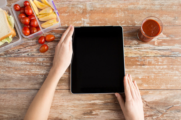 close up of woman with tablet pc food on table - Foto, Imagen