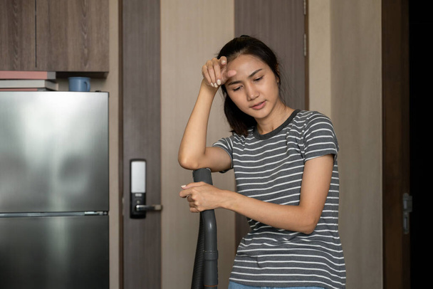 Mladá žena v domácnosti otírá pot na čele pocit vyčerpání po práci v domácnosti. - Fotografie, Obrázek