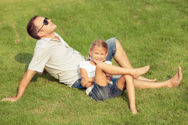 Vater und Tochter spielen tagsüber auf dem Rasen. - Foto, Bild