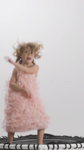 маленькая девочка прыгает на батуте в замедленной съемке в вертикальном положении - Кадры, видео