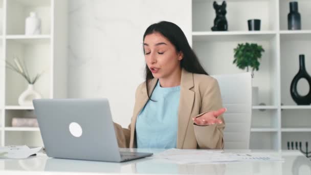 Vertoornd Arabisch of Indiaas zakenvrouw, werknemer, financieel directeur, zit op het werk in een kantoor, kijkt naar laptop scherm, kreeg slechte prestaties resultaten van werknemers, schreeuwen - Video