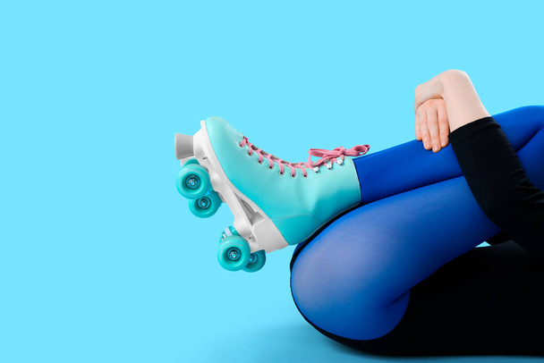 benen van vrouw in rolschaatsen op blauwe achtergrond - Foto, afbeelding