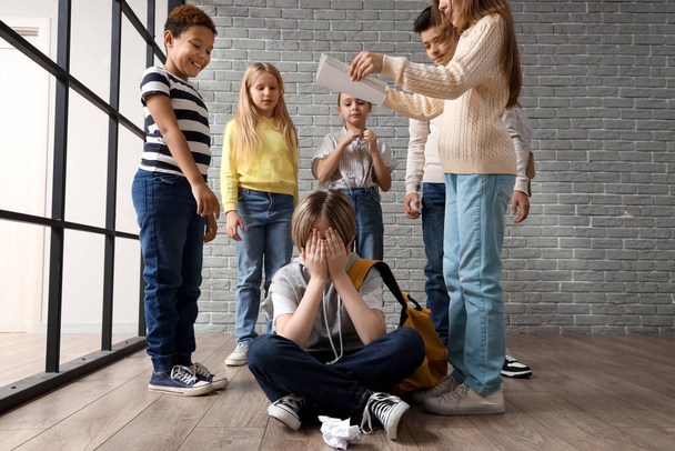 Petit garçon intimidé avec ses camarades de classe pleurant à l'école - Photo, image