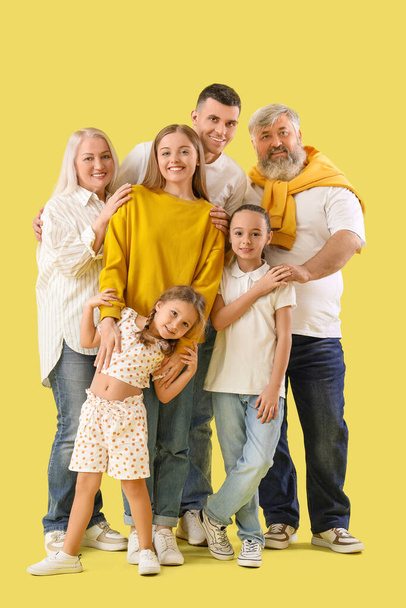 黄色の背景に抱擁する大きな家族 - 写真・画像