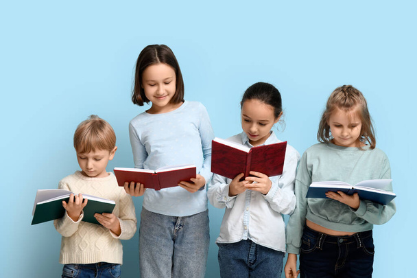Little children reading books on blue background - Photo, Image