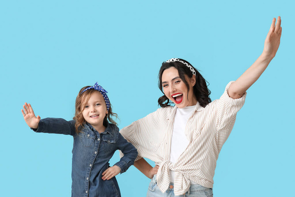 Щаслива пін-ап жінка і її дочка на синьому фоні - Фото, зображення