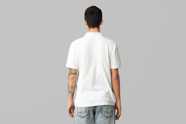 Handsome young man in stylish white t-shirt on grey background, back view - Zdjęcie, obraz