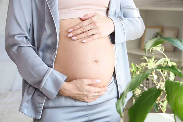 Nuori raskaana oleva nainen makuuhuoneessa, lähikuva
 - Valokuva, kuva