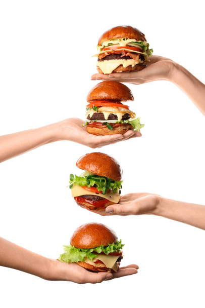 Mãos femininas segurando saborosos hambúrgueres no fundo branco - Foto, Imagem