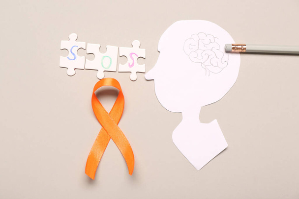 Narancs szalag, papír emberi fej és szó SOS szürke háttérrel. Sclerosis multiplex Tudatosság Hónap - Fotó, kép