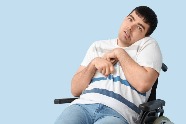 Jovem em cadeira de rodas em fundo azul. Mês Nacional de Conscientização sobre Paralisia Cerebral - Foto, Imagem