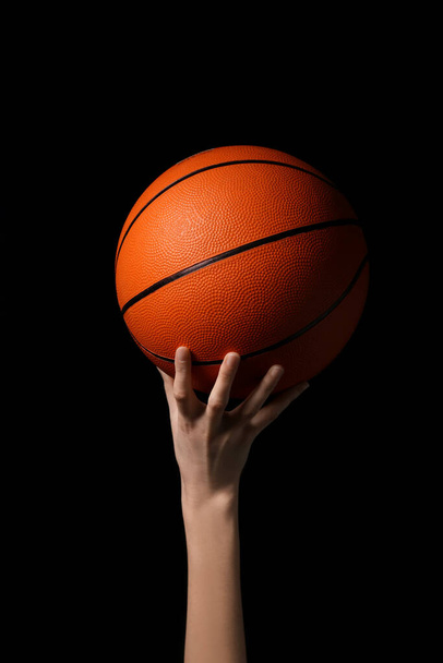 Young female basketball player with ball on black background - Photo, Image